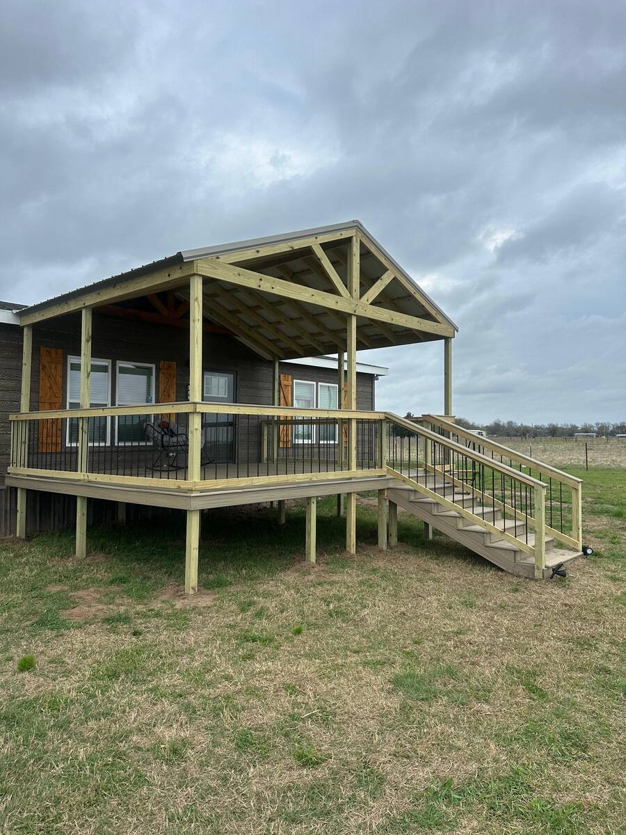 Backyard deck with metal railings and gable cover