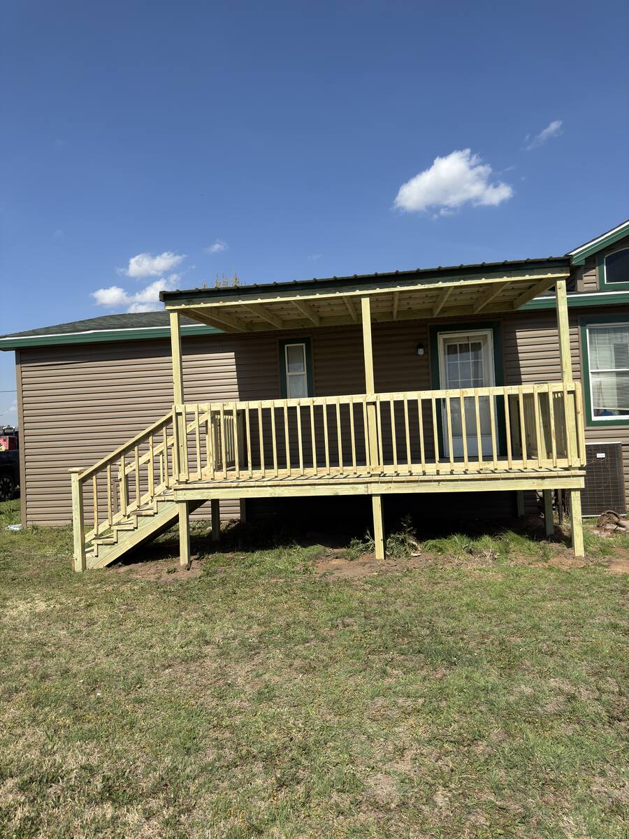 Front entry deck with handrails on dark-stained home