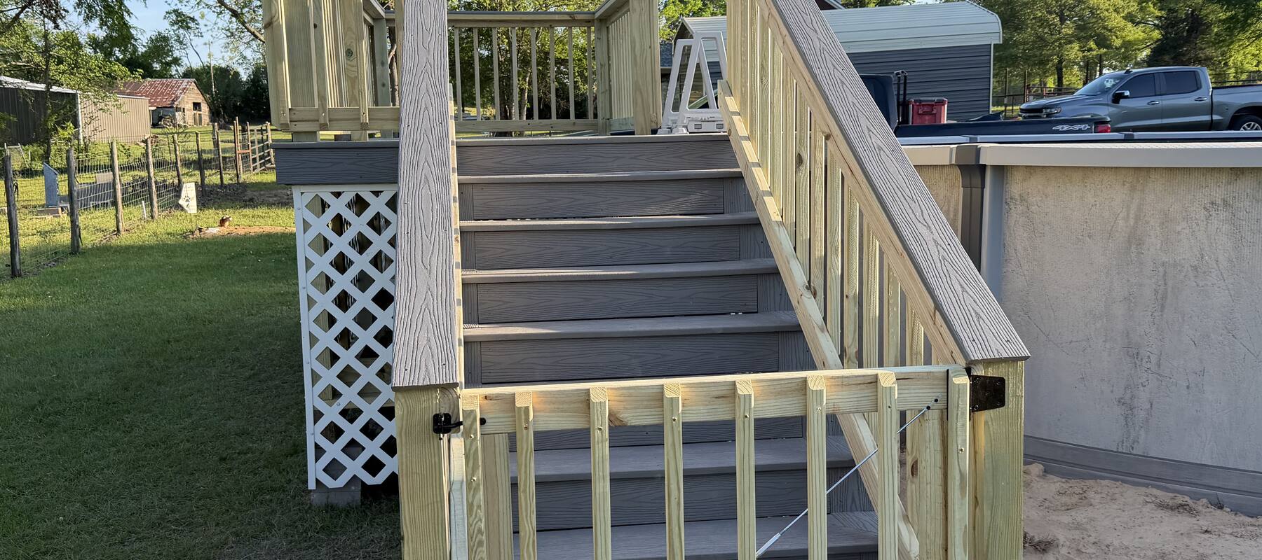Above-ground pool deck with stairs and gate by Lavell Decks